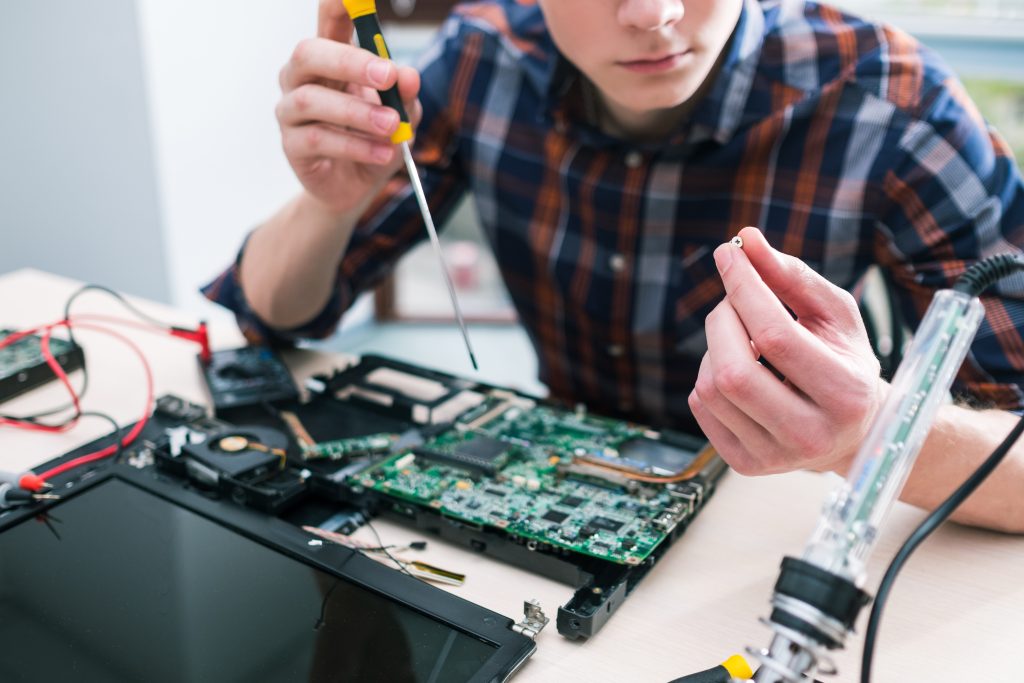 Homem mexendo em uma placa de computador