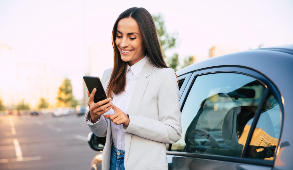 Mulher motorista observa seu celular