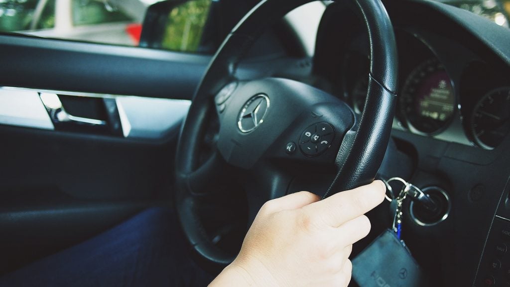 Motorista segura o volante do carro