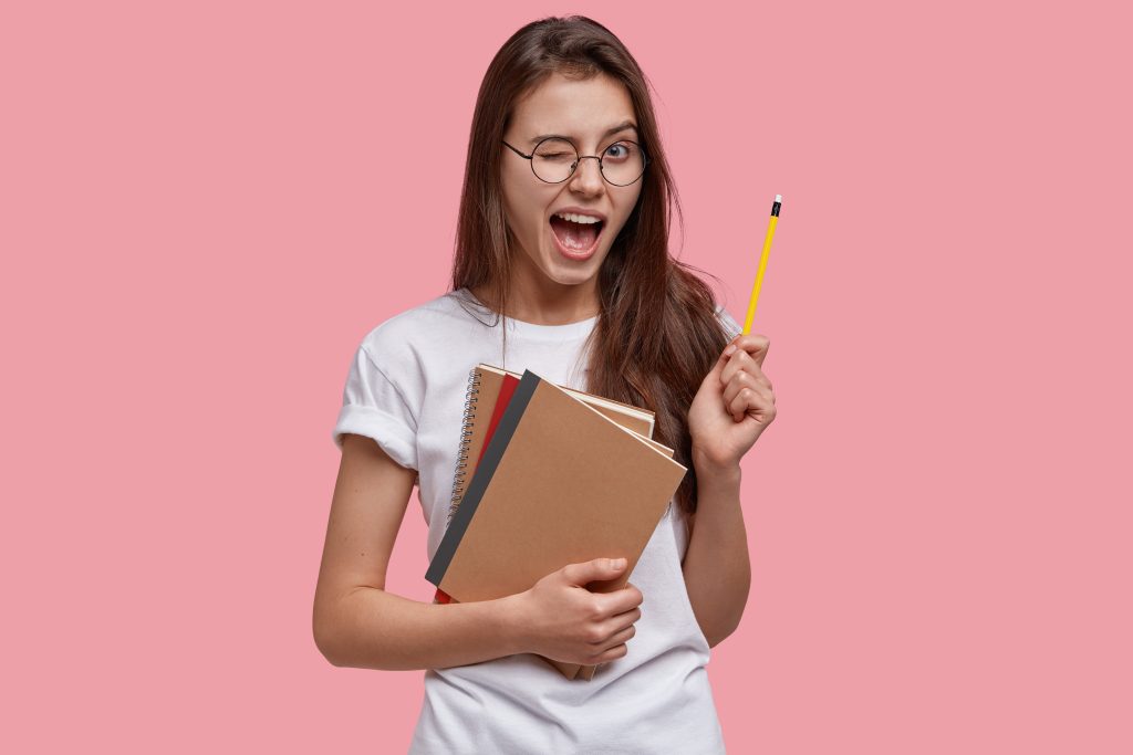 Mulher com livros e lápis na mão