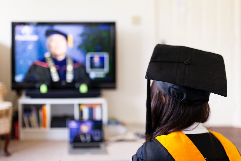 Mulher assiste aula vestida com roupas de formatura