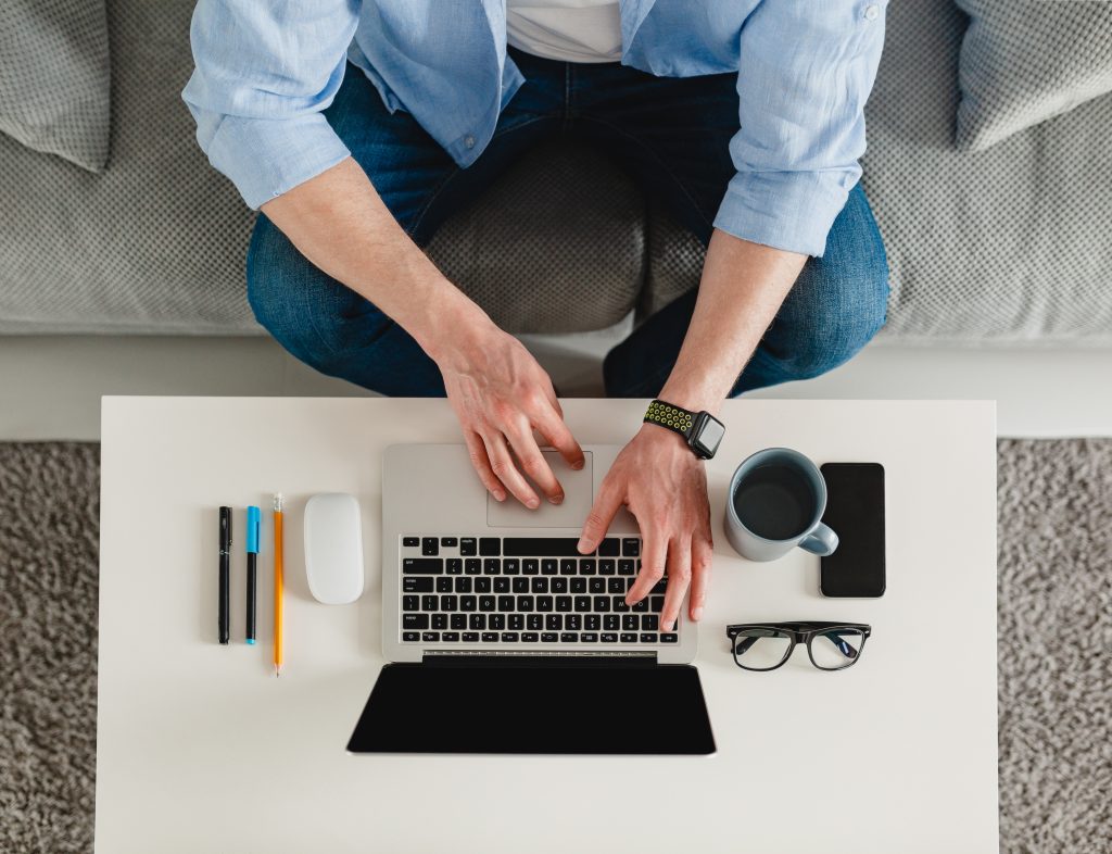 Homem trabalha em casa com um computador