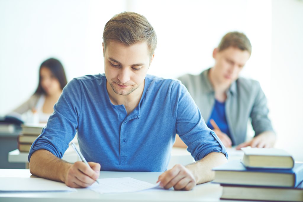 Homem estuda em sala de aula com livros