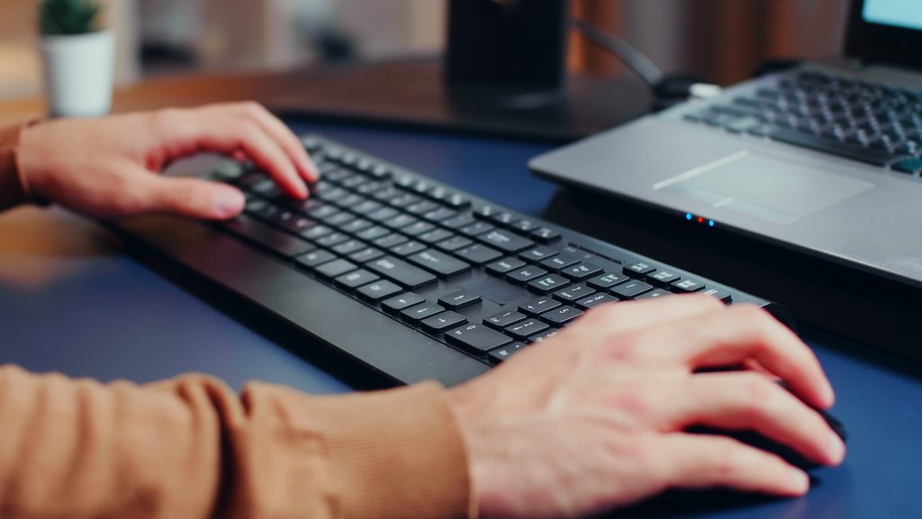 Mãos de homem usando teclado