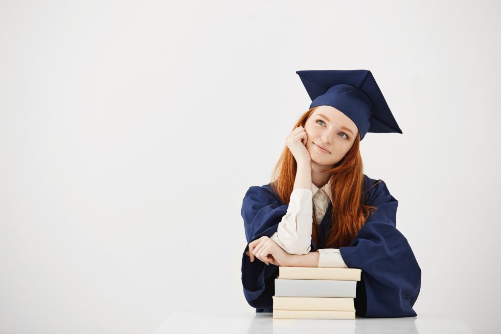 Mulher com roupa de graduação pensando