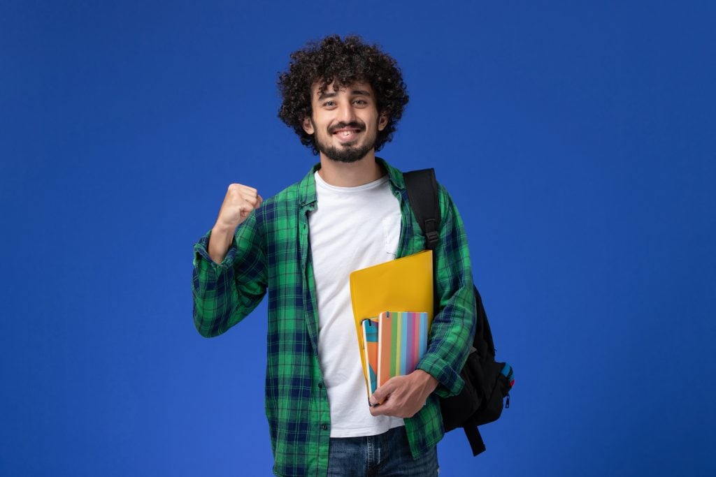 Homem comemora com livros em mão