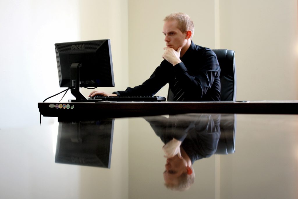 Homem pensativo usando computador