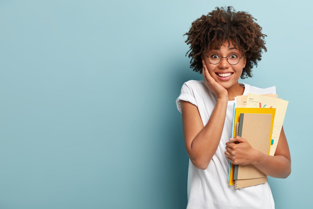 Mulher preocupada com livros em seus braços