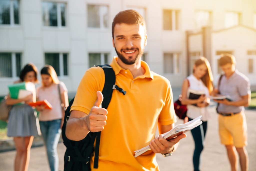 Homem acena com livros nas mãos