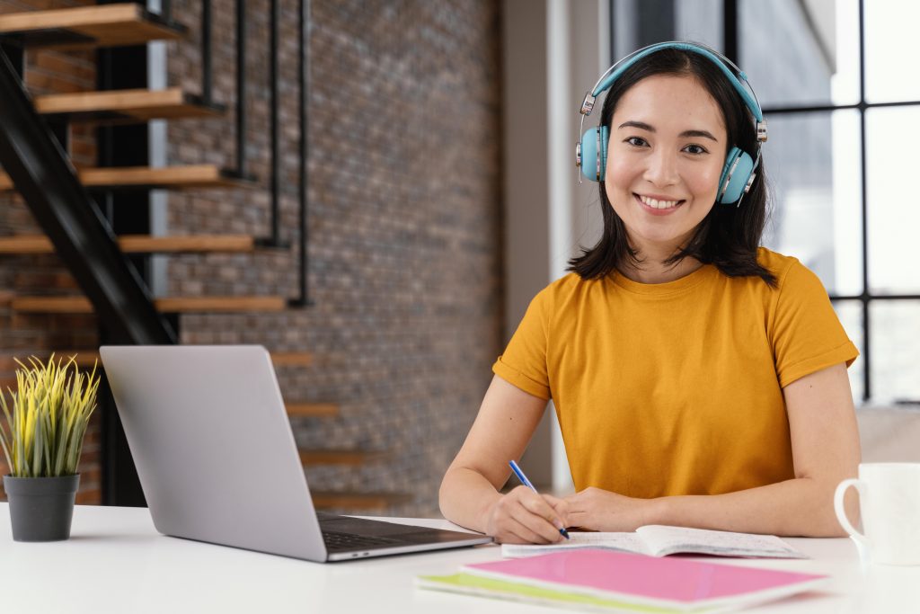 Mulher estudando com computador e fone