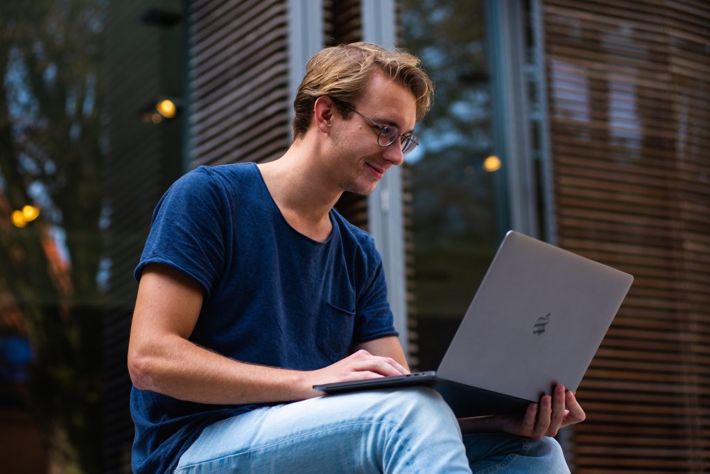 Jovem pesquisa sobre concurso Receita Federal em seu computador