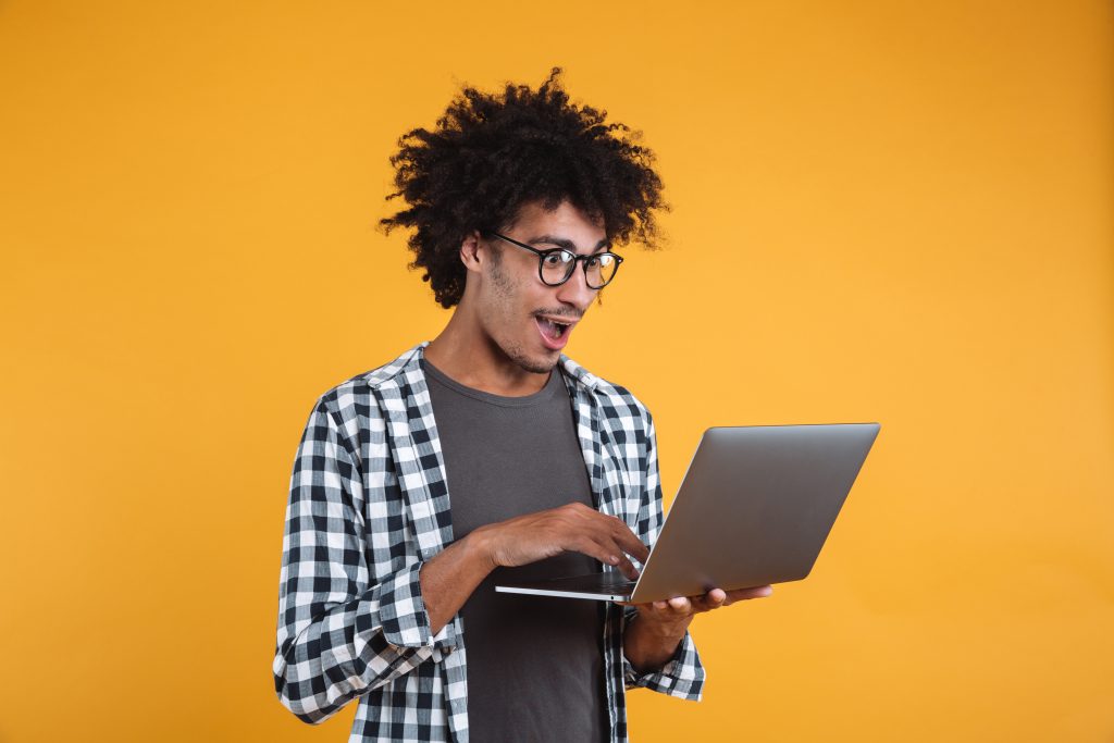 Jovem confere edital concurso Banco do Brasil em seu computador