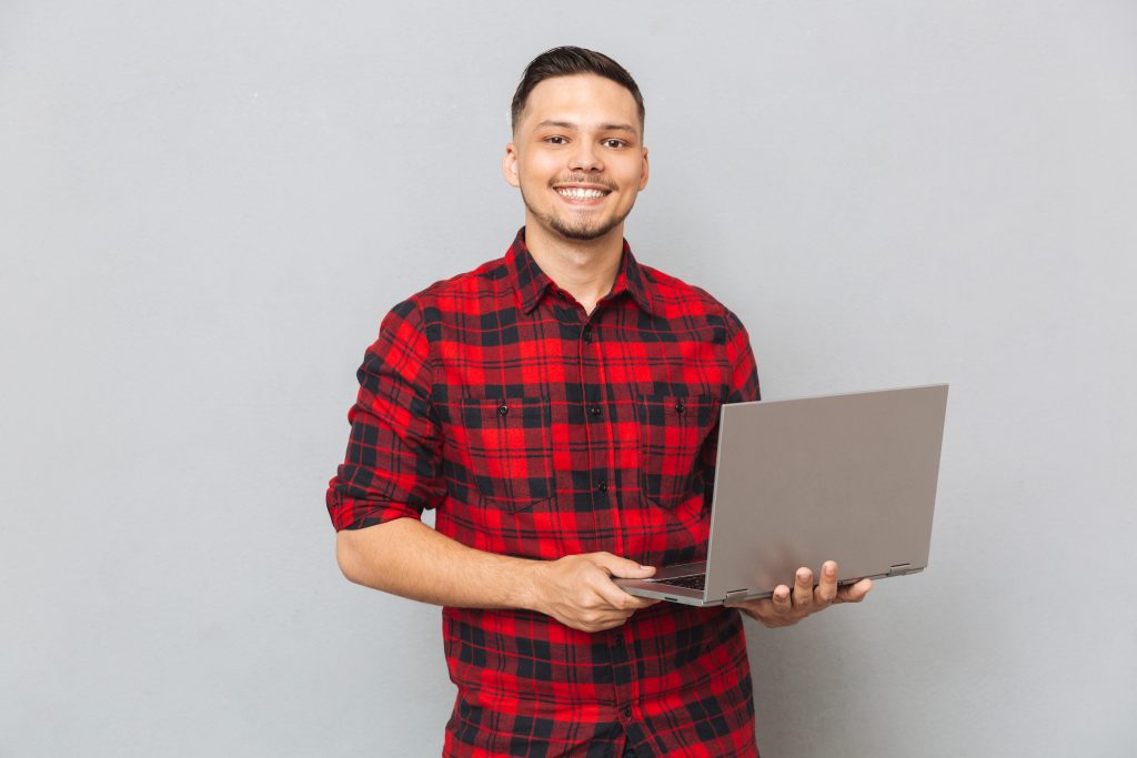 Homem sorridente segura computador