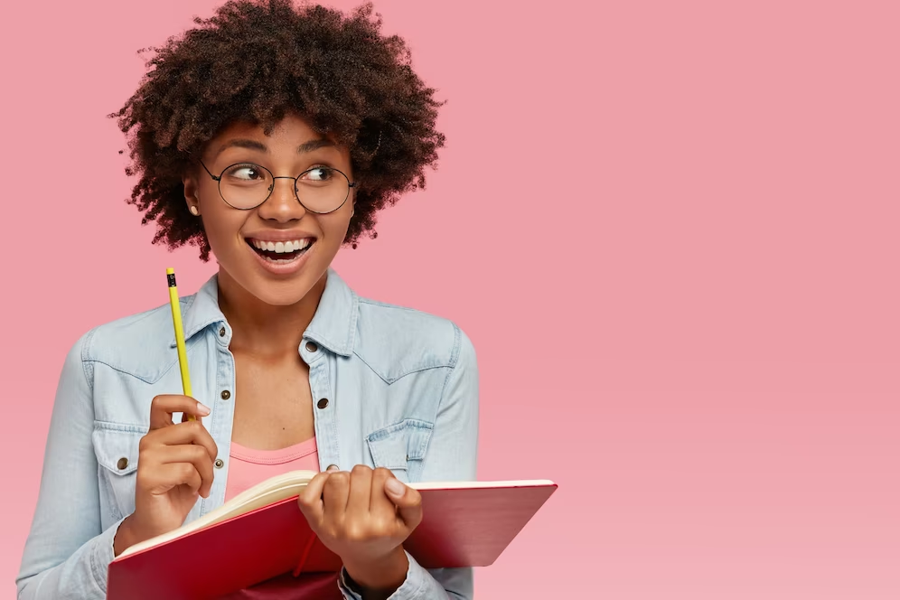 Mulher contente com caderno e lápis