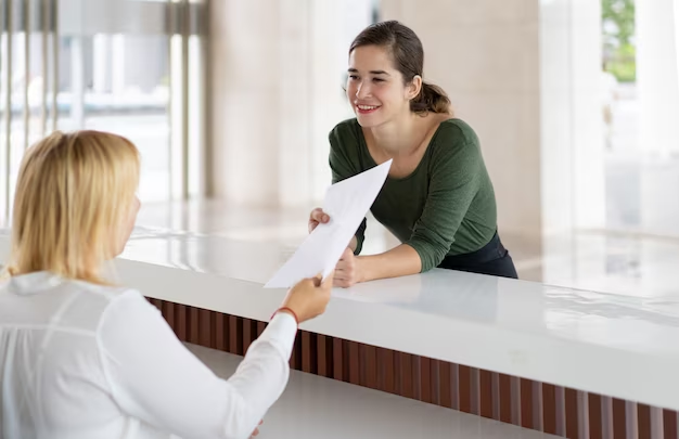 Pessoa entregando um papel para uma recepcionista