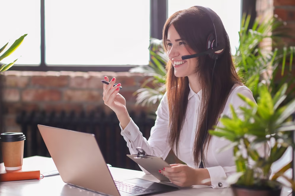 Recepcionista falando com cliente pelo telefone