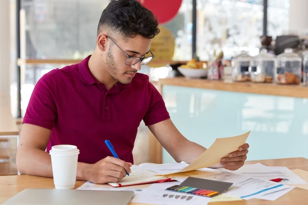 Homem estuda com papéis