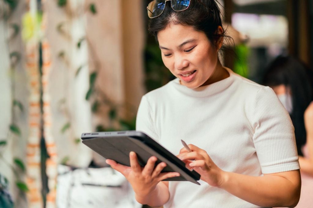 Mulher asiática usando um tablet