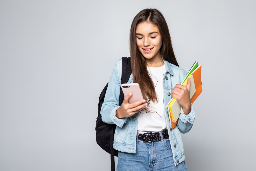 Mulher estuda para prova concurso Receita Federal com celular