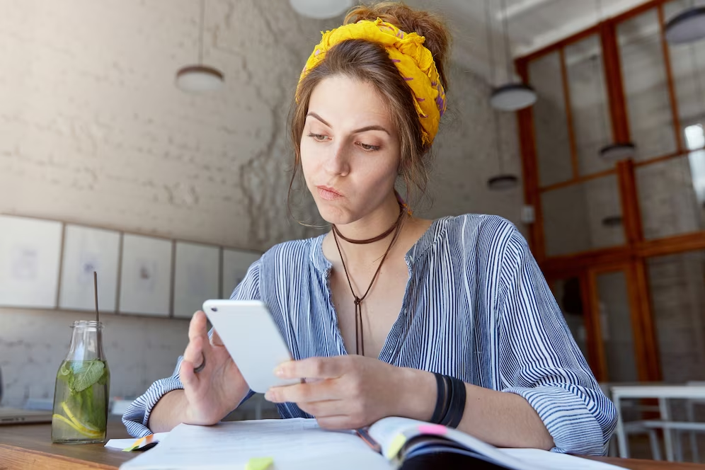 Mulher estuda com celular