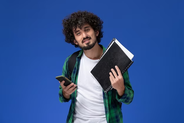 Homem segurando cadernos e celular